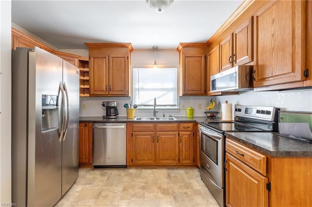 kitchen with stainless steel appliances, hanging light fixtures, and sink