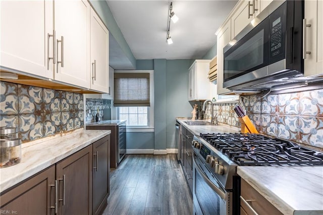 kitchen featuring backsplash, track lighting, white cabinets, sink, and appliances with stainless steel finishes