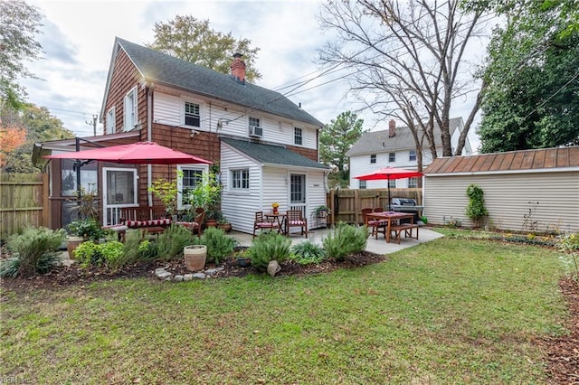 back of property featuring a lawn, an outdoor structure, and a patio