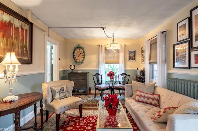 sitting room with radiator heating unit and an inviting chandelier