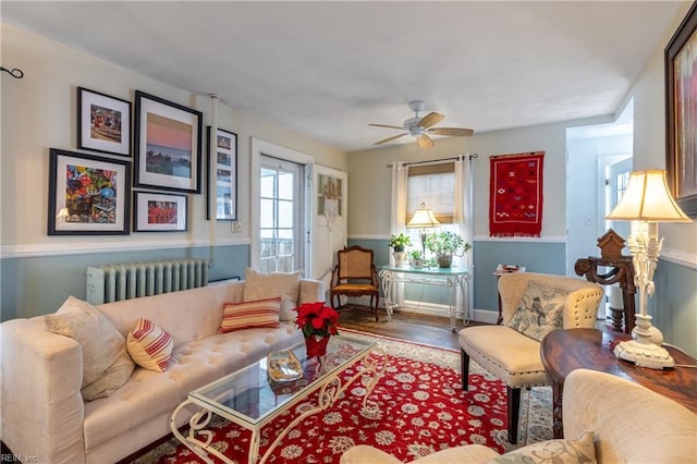 living room featuring ceiling fan, radiator heating unit, and wood-type flooring