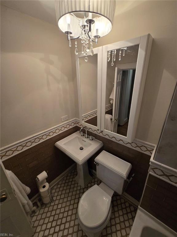 bathroom with sink, a chandelier, and toilet