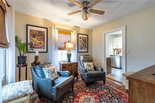 living area with ceiling fan and wood-type flooring