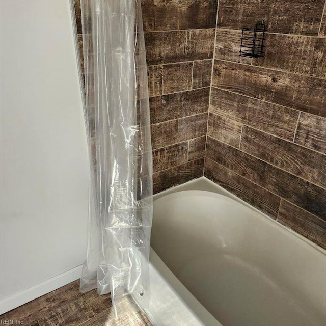 bathroom featuring hardwood / wood-style floors and shower / tub combo