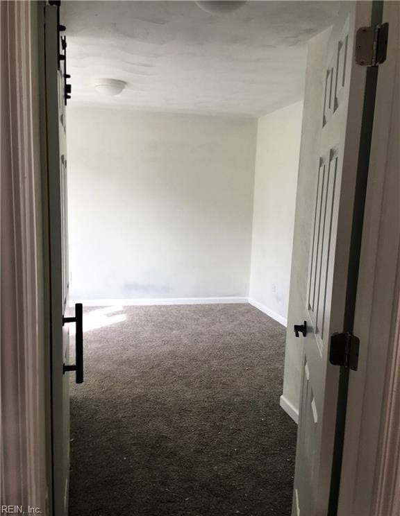 spare room with dark carpet