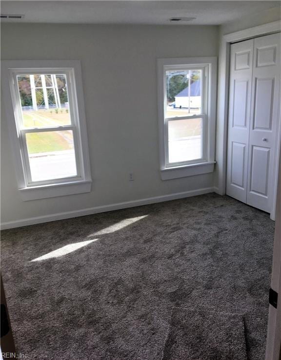 interior space featuring a closet and dark colored carpet