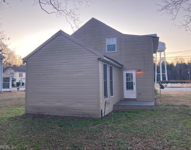 back house at dusk with a yard