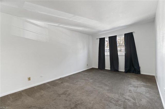 spare room with dark carpet