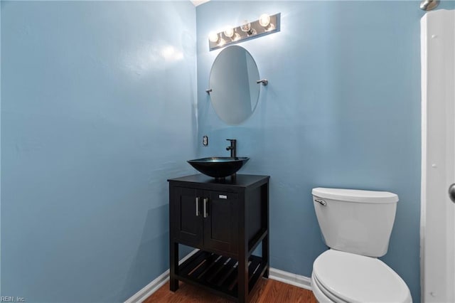 bathroom with hardwood / wood-style floors, vanity, and toilet