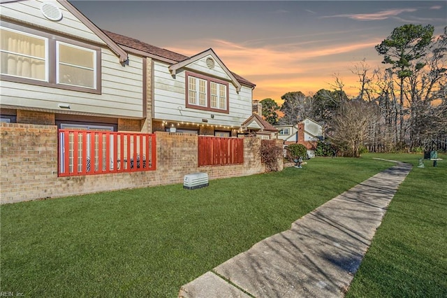 property exterior at dusk with a yard