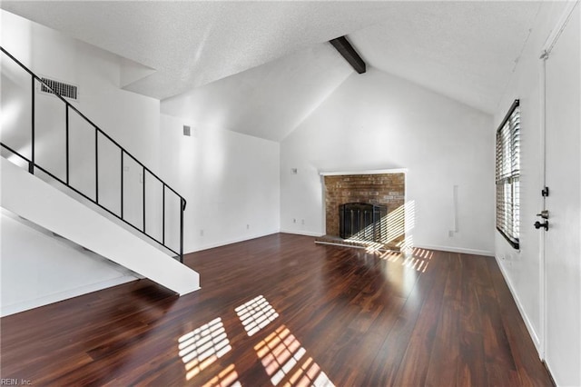 unfurnished living room featuring a fireplace, beamed ceiling, dark hardwood / wood-style floors, and high vaulted ceiling