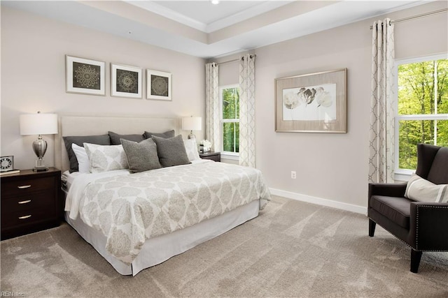 carpeted bedroom with a raised ceiling, multiple windows, and crown molding