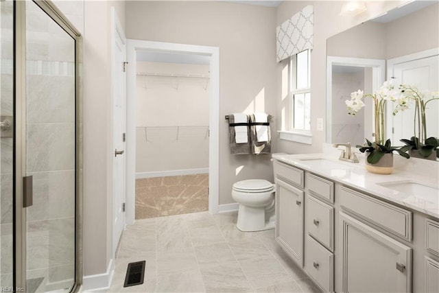 bathroom featuring vanity, an enclosed shower, and toilet