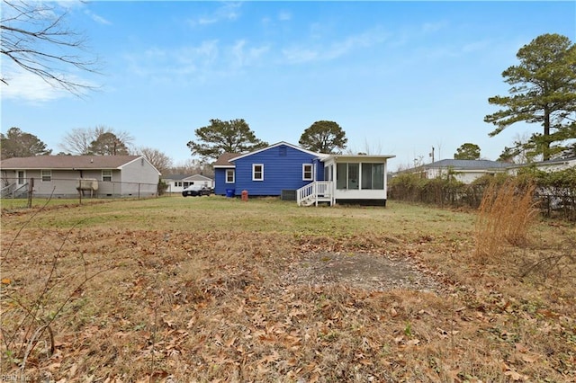 rear view of house with a sunroom and a lawn