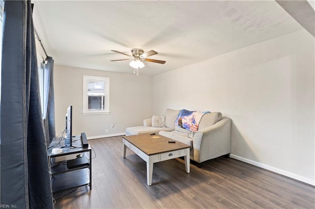 living room featuring ceiling fan and dark hardwood / wood-style floors