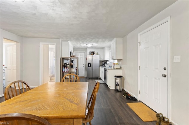 dining area with a textured ceiling and dark hardwood / wood-style floors