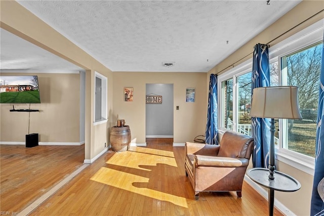 sitting room featuring a textured ceiling, hardwood / wood-style flooring, and a wealth of natural light