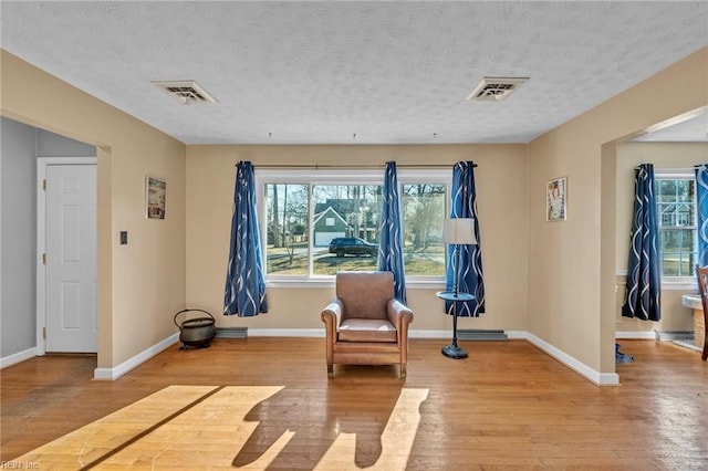 living area featuring light hardwood / wood-style floors and a textured ceiling