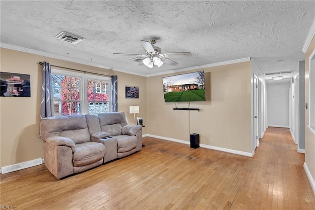 living room featuring hardwood / wood-style floors, ceiling fan, ornamental molding, and a textured ceiling