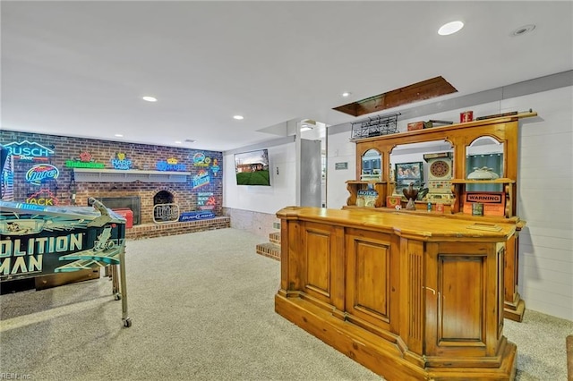 bar featuring light carpet and a brick fireplace