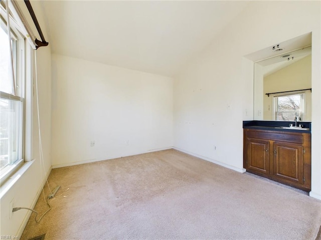 interior space with vaulted ceiling, plenty of natural light, and sink