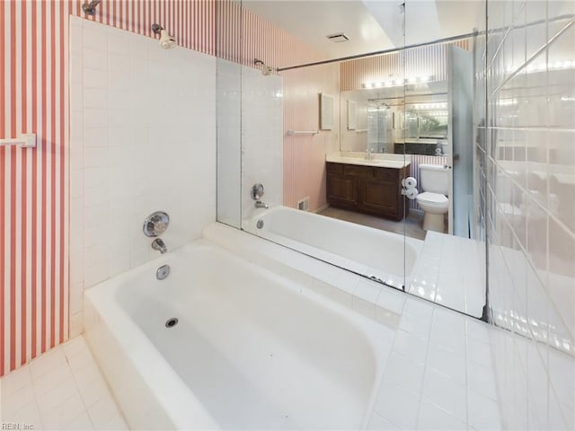 full bathroom featuring vanity, tile patterned flooring, tiled shower / bath, and toilet