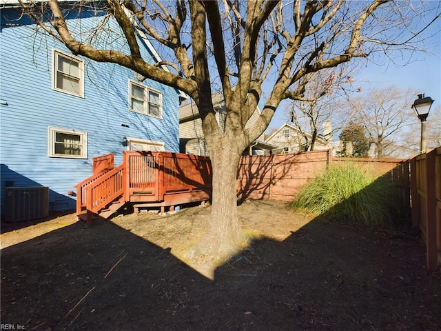 view of yard with central air condition unit and a wooden deck