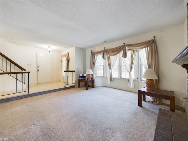 living area featuring carpet flooring and a textured ceiling