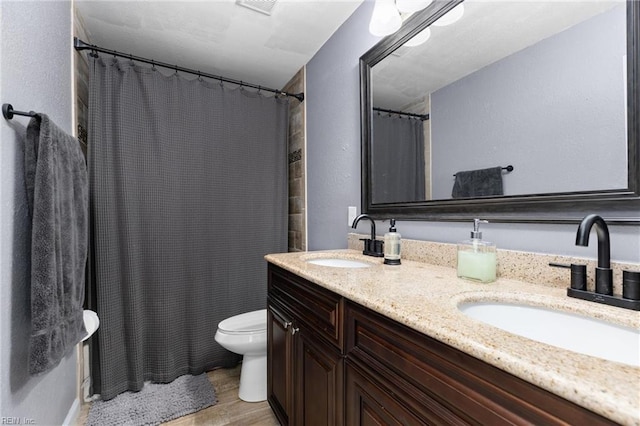 bathroom featuring wood-type flooring, vanity, toilet, and walk in shower