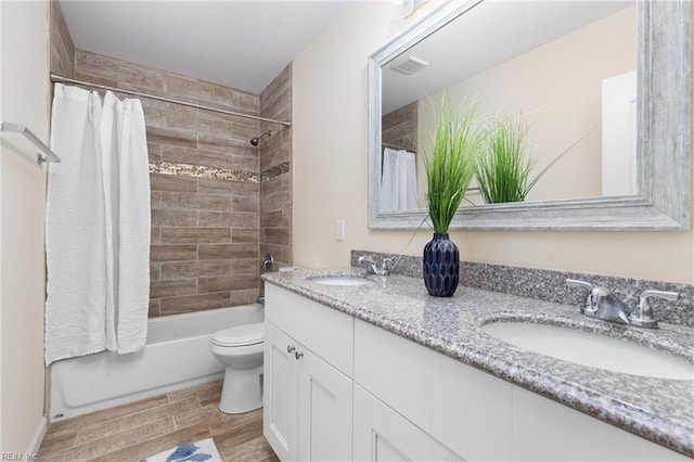 full bathroom featuring vanity, shower / bathtub combination with curtain, and toilet