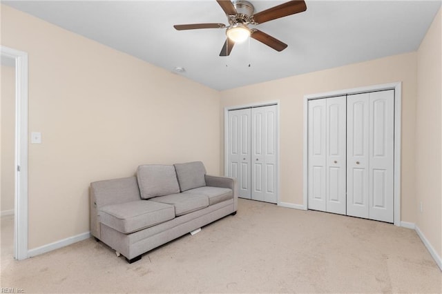 living area with light colored carpet and ceiling fan