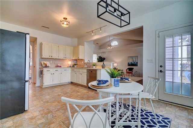 kitchen with appliances with stainless steel finishes, decorative light fixtures, a wealth of natural light, and tasteful backsplash