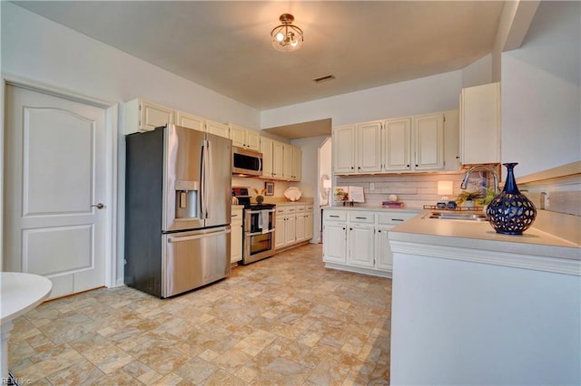 kitchen featuring stainless steel appliances, tasteful backsplash, and sink