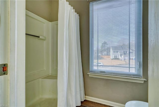 bathroom with a shower with shower curtain, hardwood / wood-style flooring, and a healthy amount of sunlight