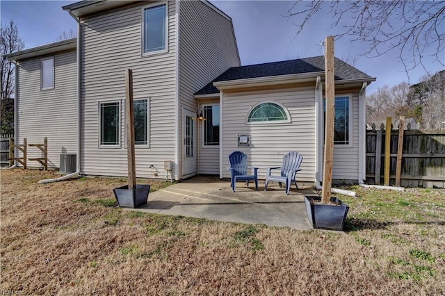 rear view of house featuring a patio, a lawn, and central air condition unit