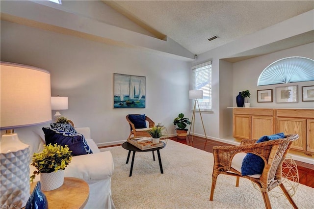 living area featuring a textured ceiling, dark hardwood / wood-style flooring, and lofted ceiling