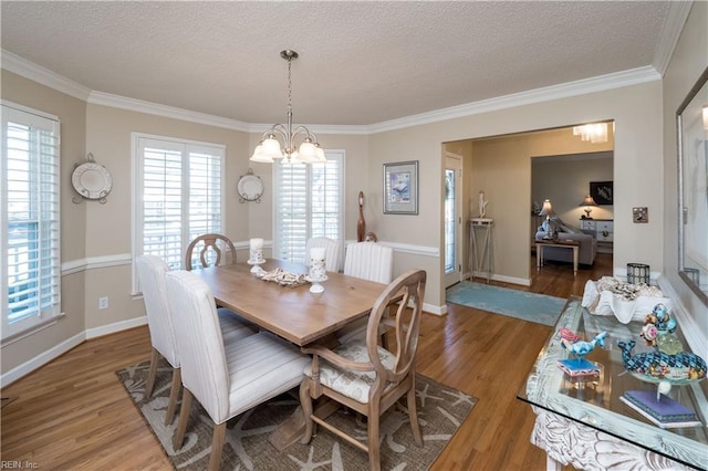 dining space with radiator, an inviting chandelier, ornamental molding, a textured ceiling, and wood-type flooring