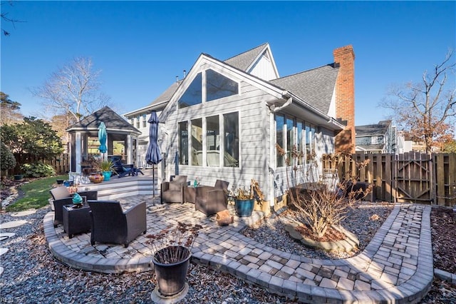 back of property featuring an outdoor living space and a patio area