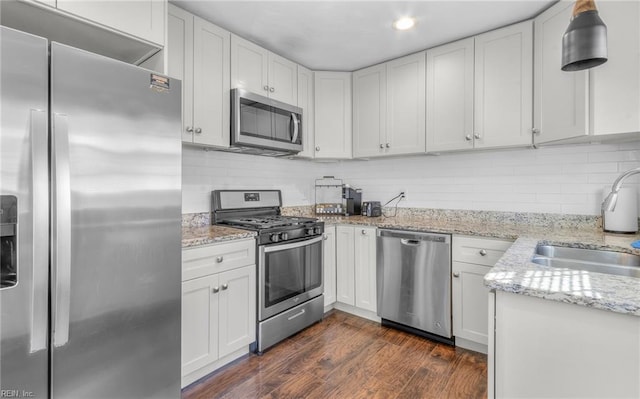 kitchen featuring white cabinetry, sink, stainless steel appliances, light stone counters, and dark hardwood / wood-style flooring