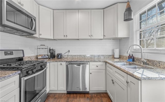 kitchen with pendant lighting, sink, white cabinetry, and stainless steel appliances