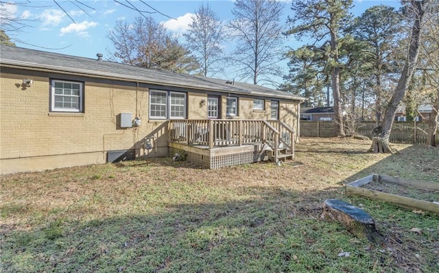 back of property with a lawn and a wooden deck