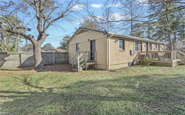 back of property featuring a lawn and a wooden deck