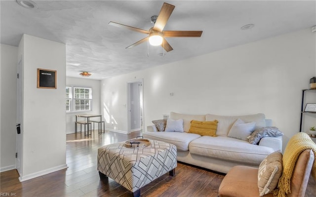 living room with dark hardwood / wood-style flooring and ceiling fan