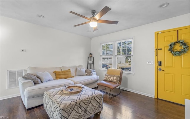 living room featuring ceiling fan and dark wood-type flooring