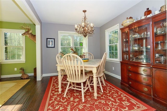 dining space with a notable chandelier, dark hardwood / wood-style flooring, and plenty of natural light