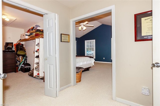 hallway with carpet floors and vaulted ceiling