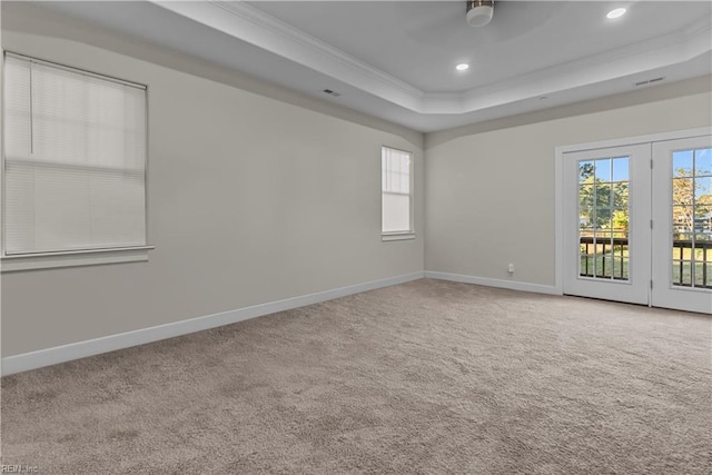 carpeted spare room with a raised ceiling, crown molding, and ceiling fan