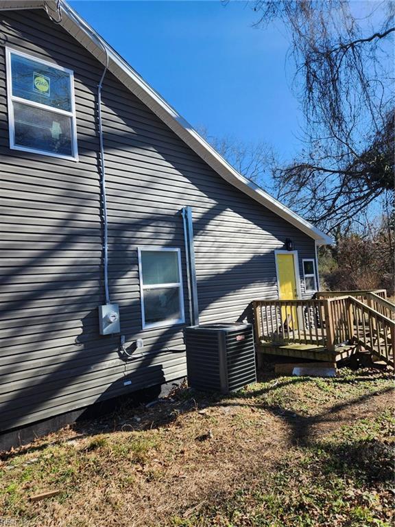 view of home's exterior with central air condition unit and a wooden deck