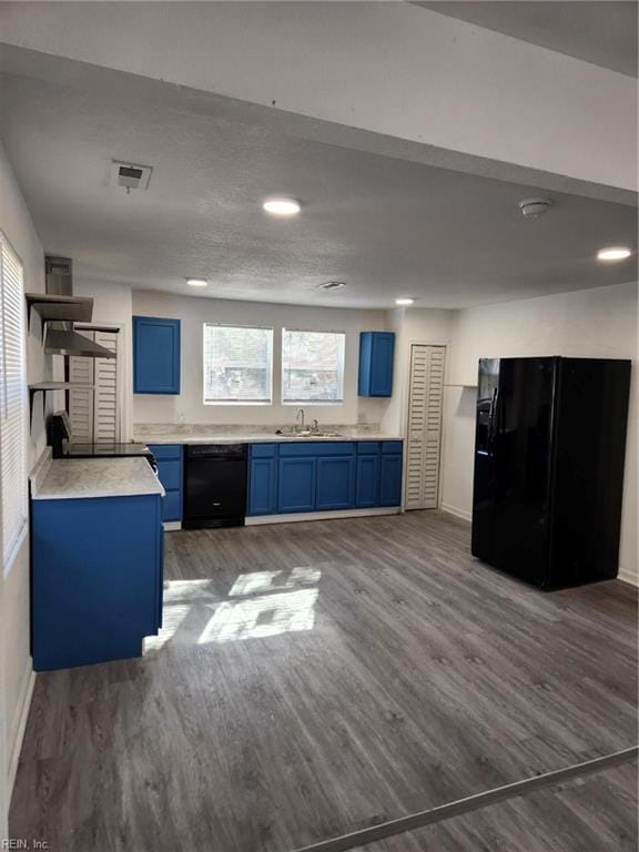 kitchen with blue cabinetry, dark hardwood / wood-style flooring, and black appliances