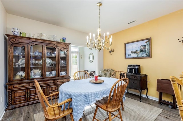 dining room with a chandelier and dark wood-type flooring